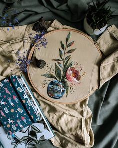 an embroidery kit with flowers and other items on top of the table next to it