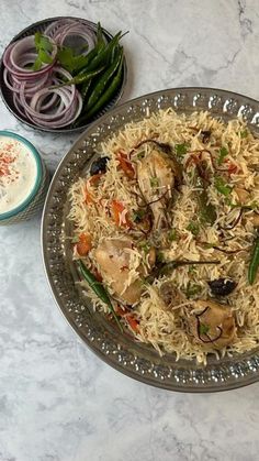 a plate full of rice and vegetables next to some other foods on a table top