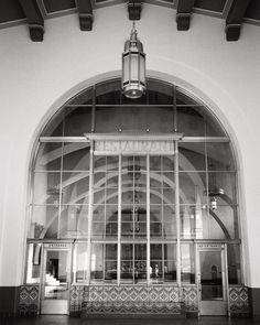 the inside of a building with large windows and a light fixture hanging from it's ceiling