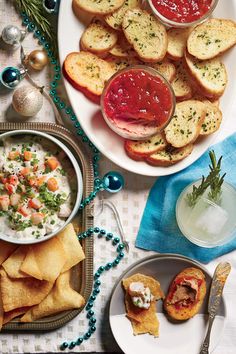 an assortment of appetizers and snacks on a table with christmas decorations around them