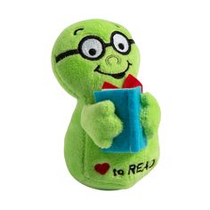 a green stuffed animal with glasses holding a book