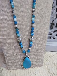 "This is a beautiful aqua and silver themed necklace. It is a total of 26\" long and the pendant alone is 2\" in size. It has dyed agate in a pretty silver base. The beads are hematite, glass, silver, sea glass and agate. Handmade and one of a kind.  Beads total 24\" long. Stunning color!" Dyed Agate, Silver Sea, Stone Beaded Necklace, Hematite Beads, Blue Agate, Aqua Blue, Baby Quilts, Sea Glass, Stone Beads