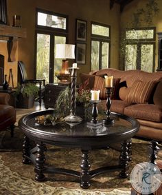 a living room filled with furniture and candles on top of a coffee table in front of a fire place