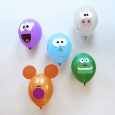 three balloons with faces and ears attached to them