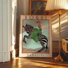 a poster is sitting on the floor in front of a lamp and a framed photograph