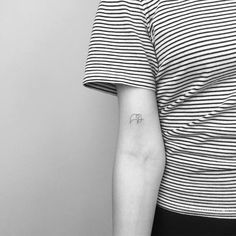 a person with a small elephant tattoo on their left arm and the other arm behind her