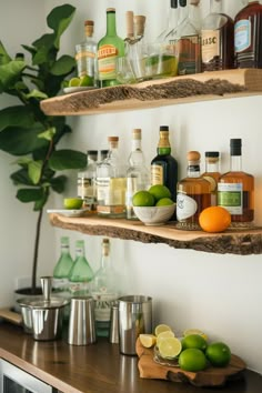 two wooden shelves filled with liquor bottles and limes