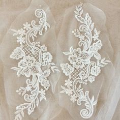 two white lace appliques on sheer fabric