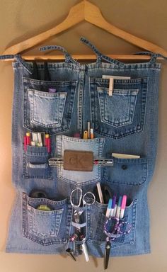 a pair of jeans hanging on a wall with scissors, pens and pencils in it