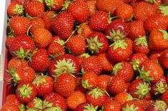 a box filled with lots of ripe strawberries