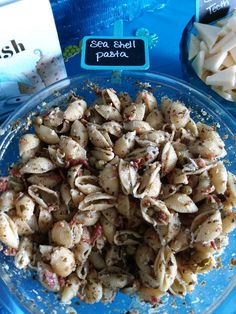 pasta shells and other food items on a blue plate with a sign that says sea shell pasta