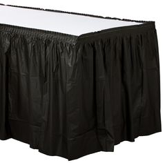 a black bed skirt with white sheets on it