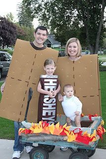 two adults and one child are standing in front of a cardboard box with the word hope on it