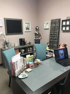 a desk with a laptop computer on top of it next to a chair and other items