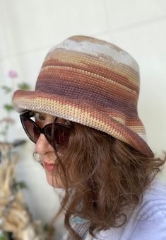 This beautiful  crochet bucket hat is made with a premium cotton mix in a scheme of pastel colors of brown and cream.  It's a very stylish accesory for summer time; chic, soft and comfortable. It's a great sun visor in your daily use, at the beach and at fun places like summer festivals. The material is very soft and firm at the same time; fits very well and feels very comfortable on the head. It is so flexible that you can shape and use the brim differently as you wish. SIZE: M / L ------ * Cir Brown Crochet Hat For Summer, Brown Brimmed Cotton Bucket Hat, Handmade Beige Yarn Bucket Hat, Handmade Brown Cloche Hat With Wide Brim, Knitted Cotton Bucket Hat With Curved Brim, Hand Knitted One Size Bucket Hat, Brown Crochet Bohemian Bucket Hat, Adjustable Crochet Brown Bucket Hat, Handmade Brown Bucket Hat For Spring