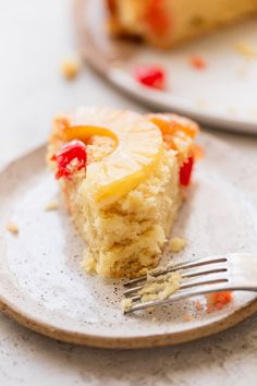 a piece of pineapple upside down cake on a plate with a fork