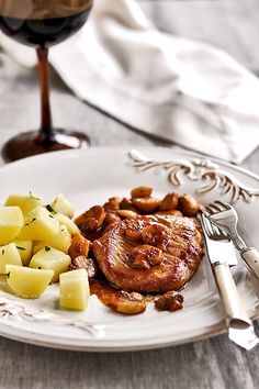 a white plate topped with meat and potatoes