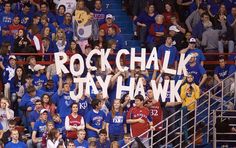 fans hold up signs in the stands during a game