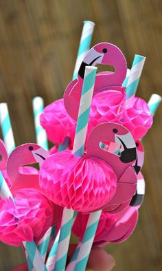 pink flamingos and blue striped straws with paper cups in the shape of flamingos