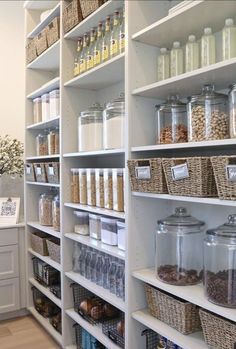 an organized pantry with lots of items on the shelves and baskets in front of them