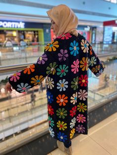 a woman is standing on an escalator with her arms out and looking at the ground