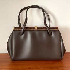 Description: Vintage Brown Leather Tortoishell Detail Top Handle  Handbag  Measurementsstrong>Width: 33cm, Height: 19cm, Strap to Bag: 13cm Formal Brown Baguette Bag With Double Handle, Classic Brown Baguette Bag With Top Carry Handle, Classic Brown Evening Bag With Top Handle, Vintage Baguette Bag Satchel For Evening, Vintage Evening Baguette Satchel Bag, Classic Brown Evening Bag For Daily Use, Brown Handheld Evening Bag For Travel, Classic Brown Evening Bag With Detachable Strap, Evening Brown Satchel With Hasp Closure