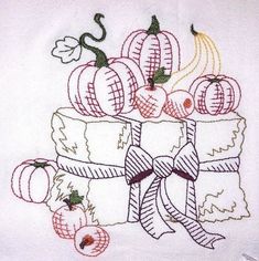 an embroidered piece of cloth with fruit on it and ribbon tied around the edges,