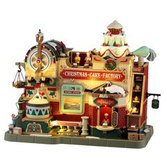 the christmas care factory is made out of wood and has various items on top of it