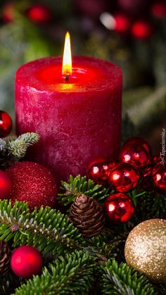 a lit candle surrounded by christmas decorations