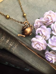 A tiny beautifully detailed solid bronze vintage teapot charm on a pretty and dainty bronze ball satellite chain with bronze lobster clasp fastening and 3cm chain extension.  The teapot is double-sided with intricate fine detailing.  Antiqued for true vintage appeal.  Comes with a printed quote card 'We're All Mad Here', a famous quote from Lewis Carroll's epic book Alice in Wonderland.  Photo of book just for illustration purposes. Chain length: Assorted lengths, choose from the menu Teapot: 1. Alice In Wonderland Quote, Teapot Necklace, Bohemian Jewelry Gift, Alice And Wonderland Quotes, Vintage Teapot, Wonderland Quotes, Were All Mad Here, Quote Cards, Tea Pots Vintage