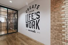 an office with a brick wall and glass doors that says create your life's work