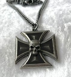 Awarded for dastardly deeds. A no-nonsense pendant that's perfect for the circle pit A pewter Iron Cross pendant with a skull at its centre and translucent black enamel infill. The pendant comes with a velvet gift pouch. Made by Kiss of a red rose with help from Alchemy England 1977. Collectible Black Stainless Steel Necklace, Gothic Skull Jewelry For Biker Events, Gothic Jewelry For Biker Events And Halloween, Black Skull-shaped Engraved Jewelry, Black Skull Shaped Engraved Jewelry, Black Engraved Skull Jewelry, Black Skull Engraved Jewelry, Vintage Black Skull Jewelry, Black Skull Necklace With Oxidized Finish