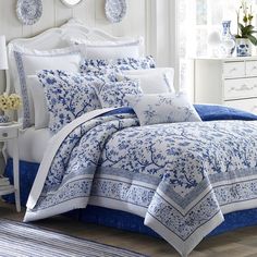 a bed with blue and white comforters in a room