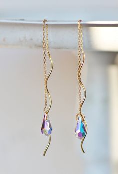 "Stunning new earrings made using unique, 14K gold vermeil threaders and Swarovski crystal. Earrings are threader style, with a twisted gold wire. From them, hangs a cut crystal drop from Swarovski. They are crystal clear with an AB coating on one side. These are amazingly cut and faceted, and sparkle beautifully. Crystals measure roughly 1/2\" (12mm) long. I offer two lengths. Large - total length 6\" long , roughly 3\" when worn doubled Short - total length 3.5\", roughly 2\" when worn doubled Gold Briolette Crystal Earrings With Ear Wire, Gold Wire Wrapped Sterling Silver Crystal Earrings, Gold Crystal Earrings With Ear Wire, Gold Briolette Crystal Earrings For Pierced Ears, Gold Crystal Jewelry Wire Wrapped, Handmade Gold Long Drop Crystal Earrings, Gold Long Drop Crystal Earrings For Jewelry Making, Threader Earrings Gold, Twisted Metal