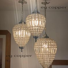 three chandeliers hanging from the ceiling in a room with an eg copper logo