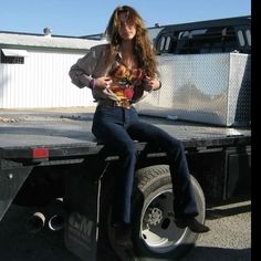 a woman sitting on the back of a truck