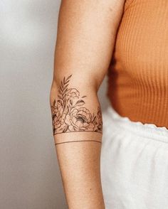 a woman's arm with a flower tattoo on the left side of her arm