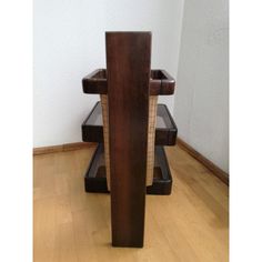 a wooden table sitting on top of a hard wood floor next to a white wall