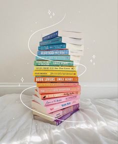 a stack of books sitting on top of a bed