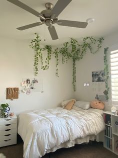 a bedroom with white walls and ivy growing on the ceiling