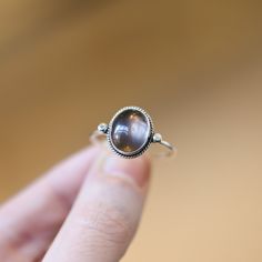 Sometimes you want to gaze down at your ring and see perfect balance and grace. That's what this Dainty Smoky Quartz Delica Ring has to offer. High-grade smoky quartz stone with a simple, sterling silver design. Perfect little ring. Lovely, traditional, dainty ring of 10X12 mm Smoky quartz cabochon set in .925 sterling silver oxidized and burnished bezel and wire. Simple, elegant and perfect. This lovely, translucent, and sparkling warm, taupe grey-colored ring is created using traditional silve Sterling Silver Cabochon Promise Ring, Nickel Free Oval Crystal Promise Ring, Oval Sterling Silver Rings With Si Clarity, Silver Birthstone Ring For Jewelry Making, Spiritual Gemstone Midi Rings, Oval Sterling Silver Ring With Si Clarity, Spiritual Sterling Silver Crystal Promise Ring, Silver Cabochon Sterling Silver Ring, Sterling Silver Ring With Si Clarity