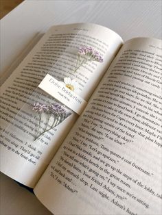 an open book with some flowers on it