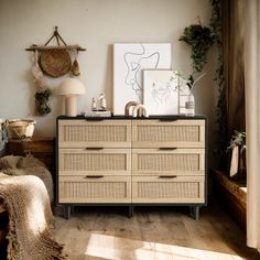 a room with a dresser and pictures on the wall