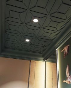 the ceiling is painted green and has birds on it