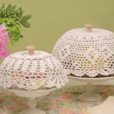 pink flowers are in a vase next to two white cake stands on top of a table