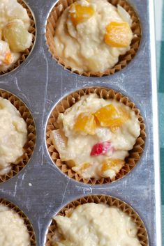 some cupcakes with fruit in them sitting on a baking tray and ready to be baked