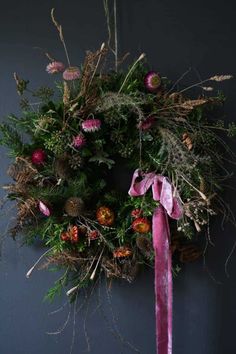 a wreath with pink ribbon hanging on the wall