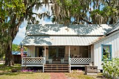 a white house with blue shutters and trees