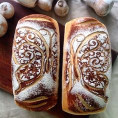 two loaves of bread sitting on top of a cutting board