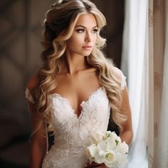 a woman in a wedding dress holding a bouquet of flowers and looking out the window